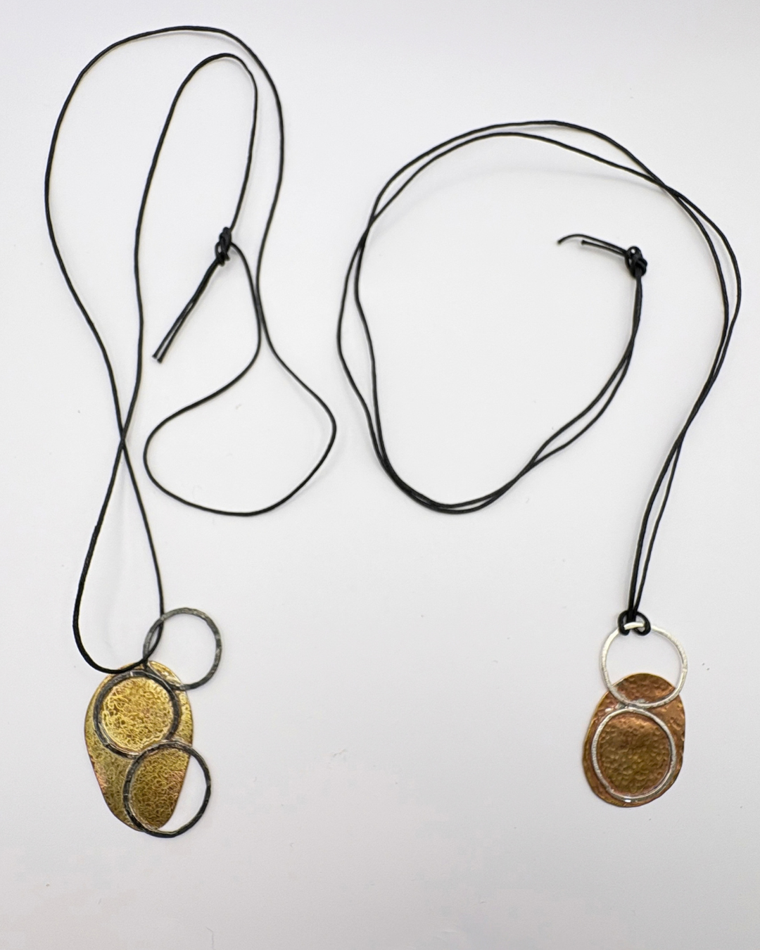 Oxidised silver and brass pendant on black string
